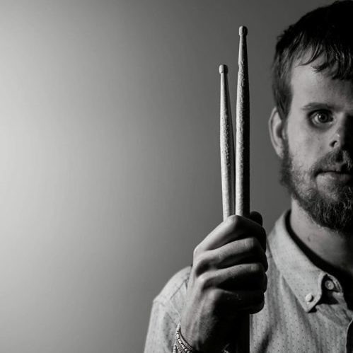 Headshot of Tommy Carroll, holding drumsticks